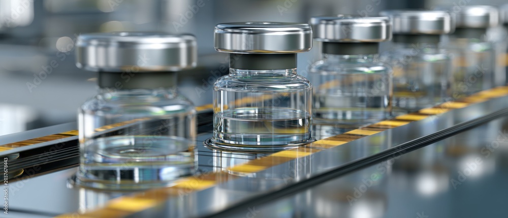 Naklejka premium Medical vials in a row on a manufacturing line close up with blur background
