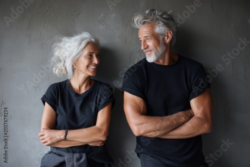 Portrait of a happy couple in their 60s dressed in a casual t-shirt over empty modern loft background
