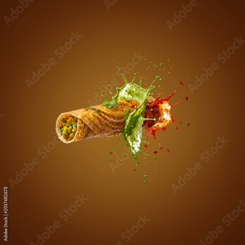 Delicious burrito with salsa and lettuce splashing
