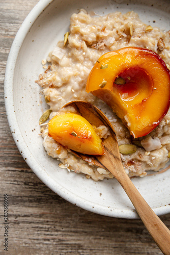 Stewed peach served over creamy oats with seeds and toppings
