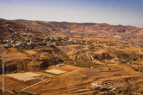 High angle view of a rural village with greenhouses and olive terraces in the arid mountains near Al-Karak, Jordan