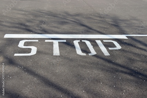 A close view of the word stop on the pavement.