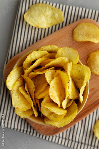 Cheese flavored potato chips in a bowl, top view.