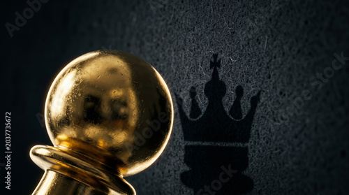 Detailed golden pawn casting a crowned king shadow on wall