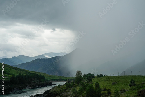 Fotografie A strong thunderstorm and a squall of rain are approaching in the mountains in s