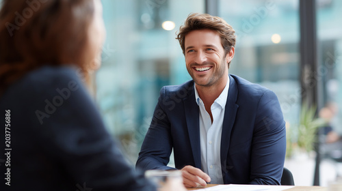Professional recruitment meeting with businessman smiling naturally at coworker, documentary style realism