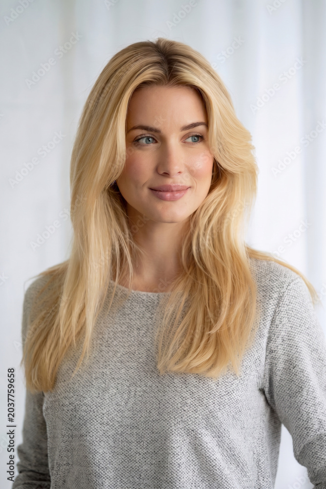 Naklejka premium Beautiful Blonde Woman with Natural Smile in Gray Sweater Clean White Background Lifestyle Portrait