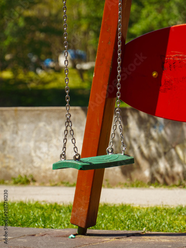 A lonely swing in a children's park awaits children who want to play.