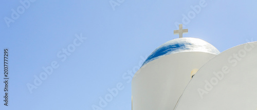 Panoramic view of white church dome with cross on blue sky background. Minimal religious architecture banner with large copy space for design