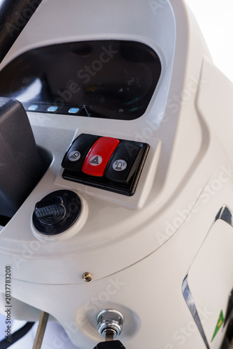 Close up of white industrial vehicle dashboard with control buttons and digital display panel