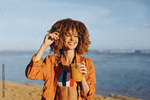 Foto Woman curly hair beach ocean smiling seaside summer travel leisure portrait on b