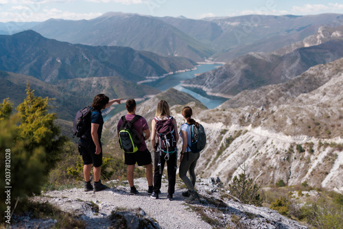 Cuadro en lienzo Group of hikers enjoying a scenic view over a mountain lake on a sunny day durin