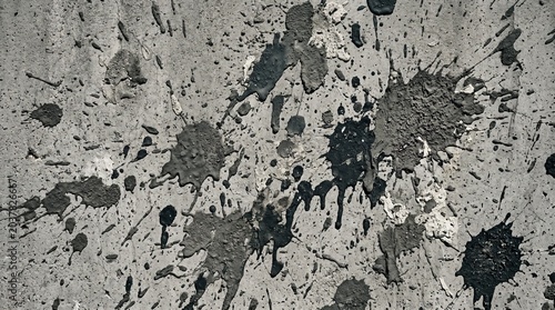 Abstract background with black paint splashes and splatters on a rough gray concrete wall texture