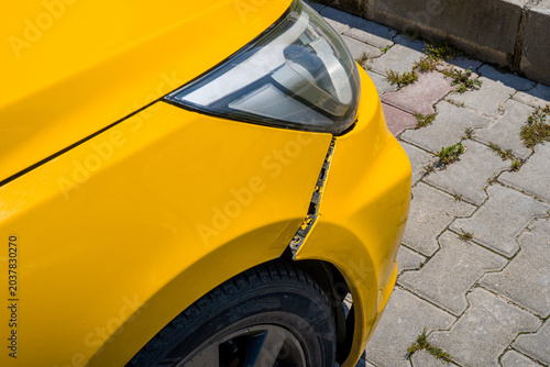 Yellow car with a damaged front fender and bumper