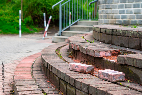 Canvas-taulu Damaged circular outdoor stairs made of paving bricks with visible defects and l