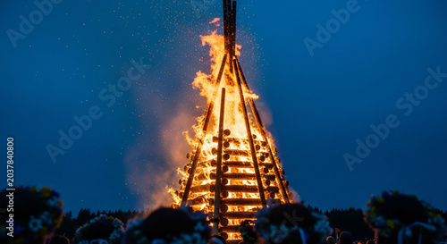 Towering Bonfire Illuminates the Night Sky with Fiery Glow.