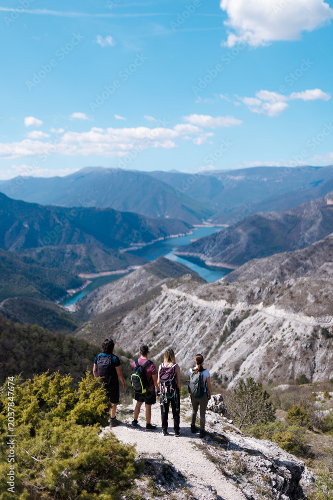 Fototapeta premium Group of hikers enjoying breathtaking mountain views in a serene landscape during a sunny day