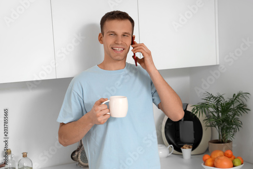 Smiling young man with cup ...