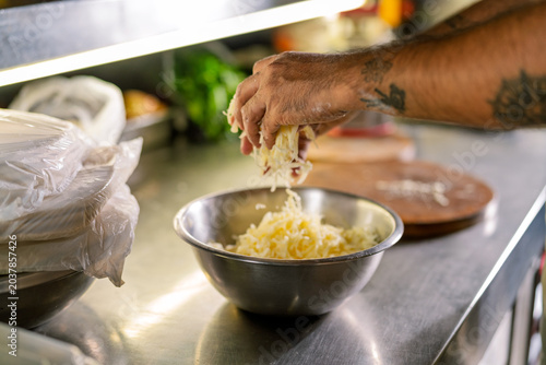 Chef's hands adding fresh cheese for artisanal pizza