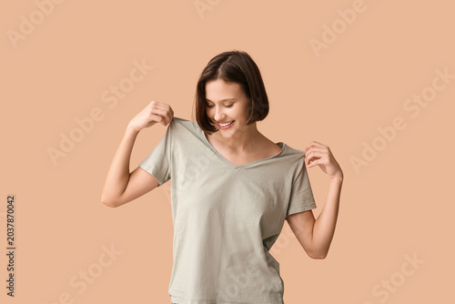 Young woman in blank t-shirt on beige background