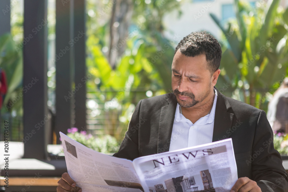 Fototapeta premium Man reading newspaper outdoors photo