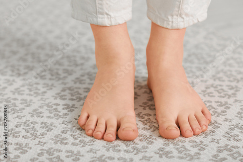 Schilderij op canvas Barefoot woman on rug at home, closeup