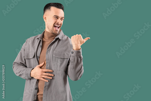 Tableau sur toile Young man laughing at something on green background
