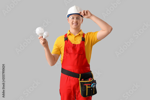 Male electrician with light...