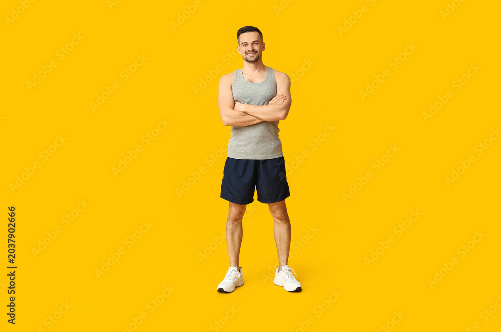 Obraz premium Handsome sporty young man on yellow background. Weight loss concept