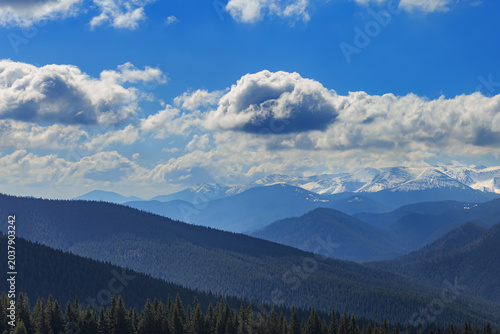 A scenic  spring view of mountain ridges with remaining snow, taken from a popular hiking trail along the Kukul Ridge. Ukrainian Carpathians, Ivano-Frankivsk Oblast.