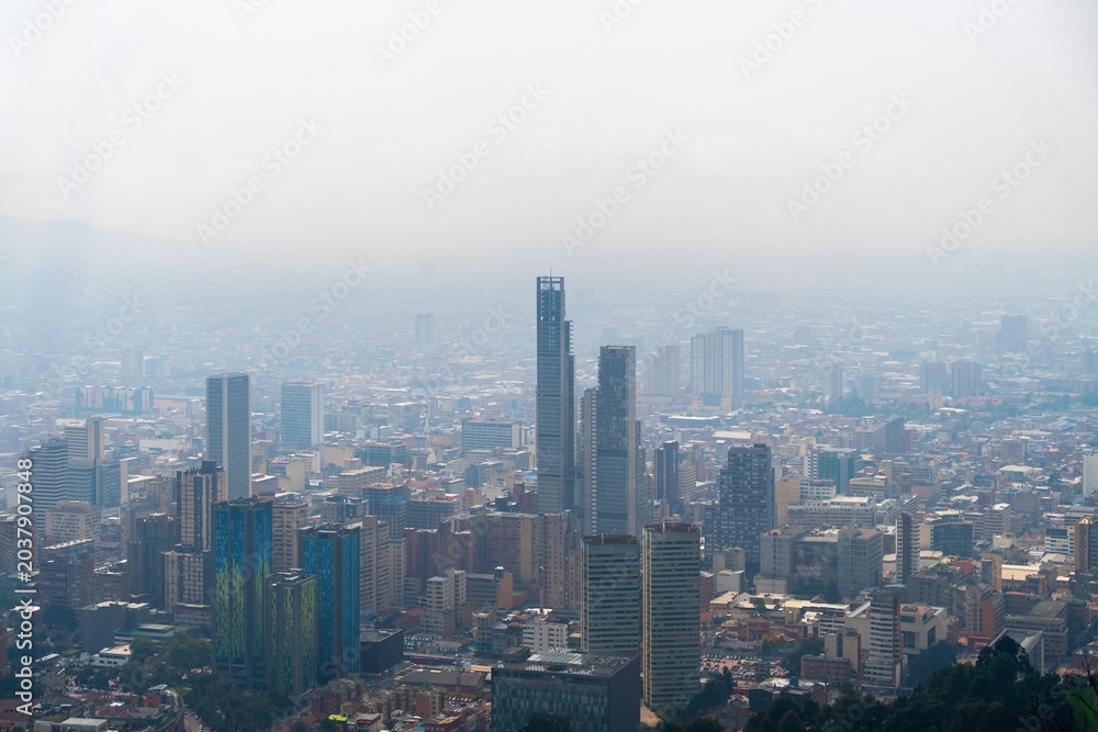 Obraz premium Aerial view of Bogotá cityscape under dramatic cloudy sky, Colombia