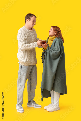 Young man giving cup of hot...