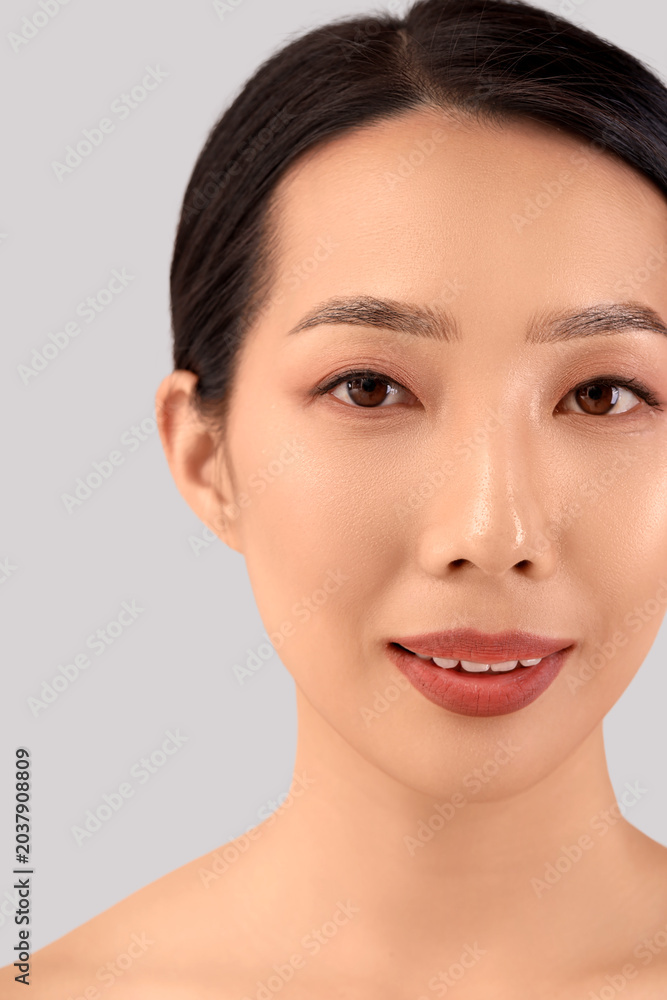 Obraz premium Beautiful Asian woman on light background, closeup