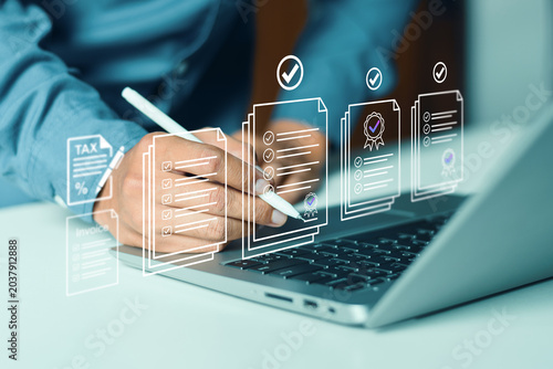 Businessman signing electronic document on laptop interface, illustrating digital signature, paperless office compliance, online tax filing, invoice auditing, and workflow automation concepts.