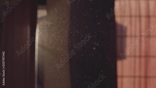 A video of beautifully moving particles in the air in a dark room, appearing when sun's rays penetrate through the cracks of window curtains. Beauty in everyday things, abstract harmony, tranquility