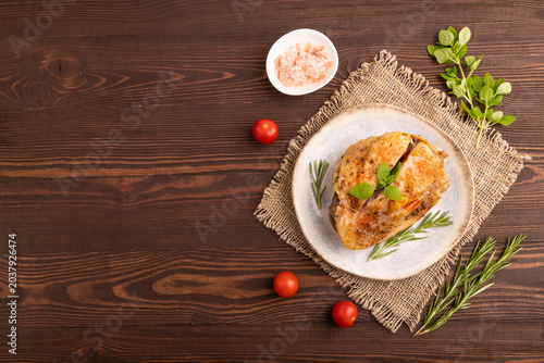 Fried Turkey Thigh with spices on plate on brown wooden, linen textile. top view, flat lay, copy space