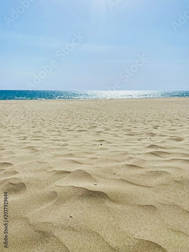 фотографія Golden sand dunes of Patara Beach against the turquoise Mediterranean Sea under clear summer skies