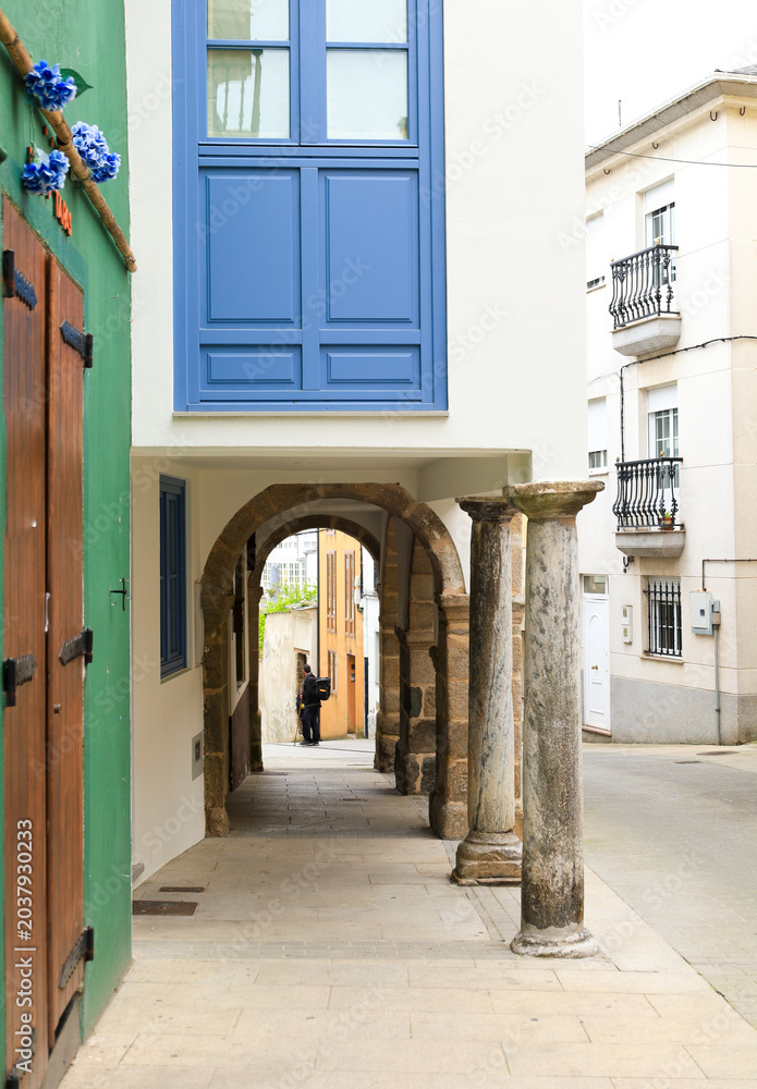 Fototapeta premium Beautiful street with arcades and pillars in the old town of Ribadeo town, Galicia