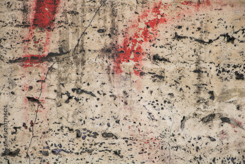 Abstract distressed concrete wall texture with red paint marks