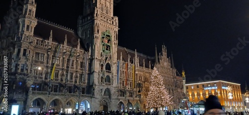 « Place historique illuminée de nuit avec architecture néogothique et sapin de Noël »
