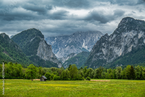 Dramatic Alpine Valley with Mountain Peaks and Meadow