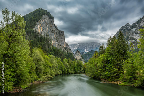 Mountain River Valley with Dramatic Storm Clouds and Forest