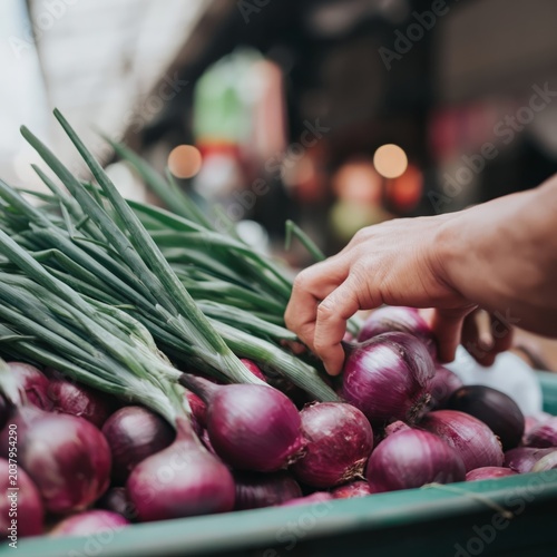 Hand Picks Red Onions at a Market in the Afternoon