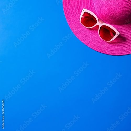 Bright Pink Hat and Sunglasses on a Blue Background Ready for Summer Fun