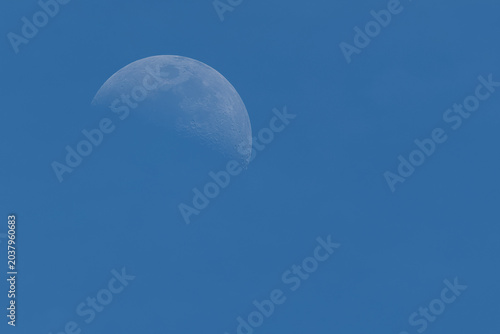 Foto Half moon in cloudless blue sky