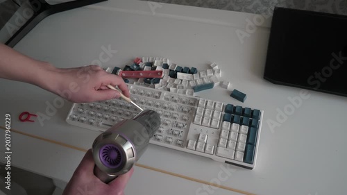 Meticulous cleaning of keyboard components. Thorough keyboard maintenance with cleaning techniques. Careful disassembly and vacuuming of keyboard keys using vacuum cleaner for thorough cleaning