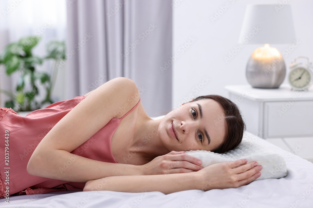 Obraz premium Woman lying on bed with orthopedic pillow at home. Space for text