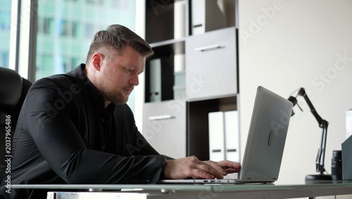 Fotografi Businessman working on laptop in modern office