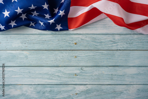 American flag draped over weathered blue wooden background for USA Independence Day celebration