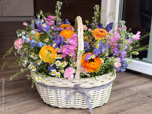 Tableau sur toile Abundant colorful ranunculus iris gerbera daisy flower basket